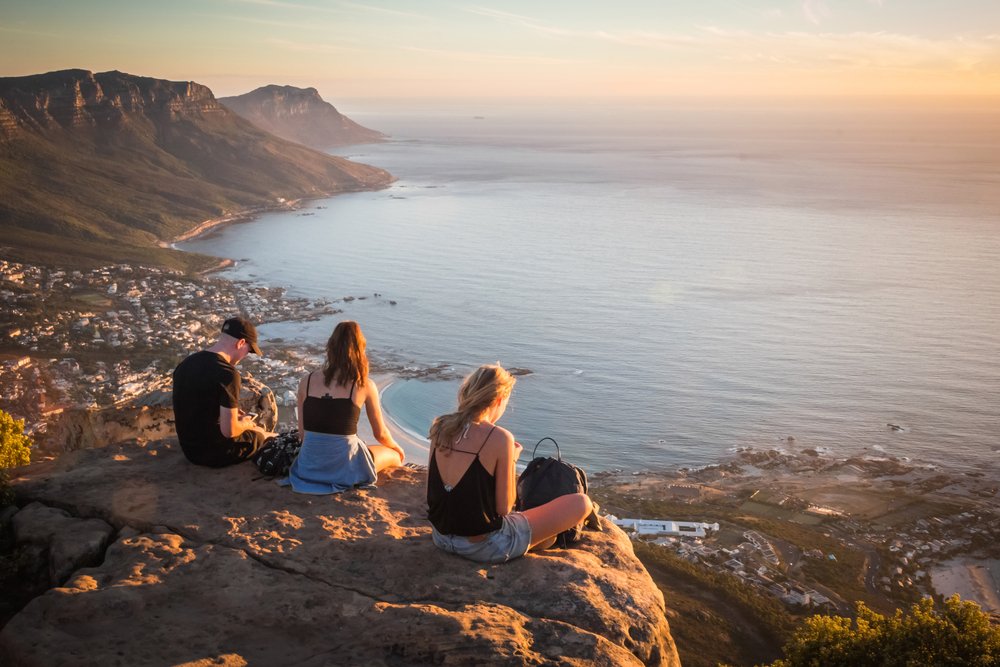 sitting on the rock on top of Lion's head mountain look at the Atlantic Ocean and Cape town city view in South Africa